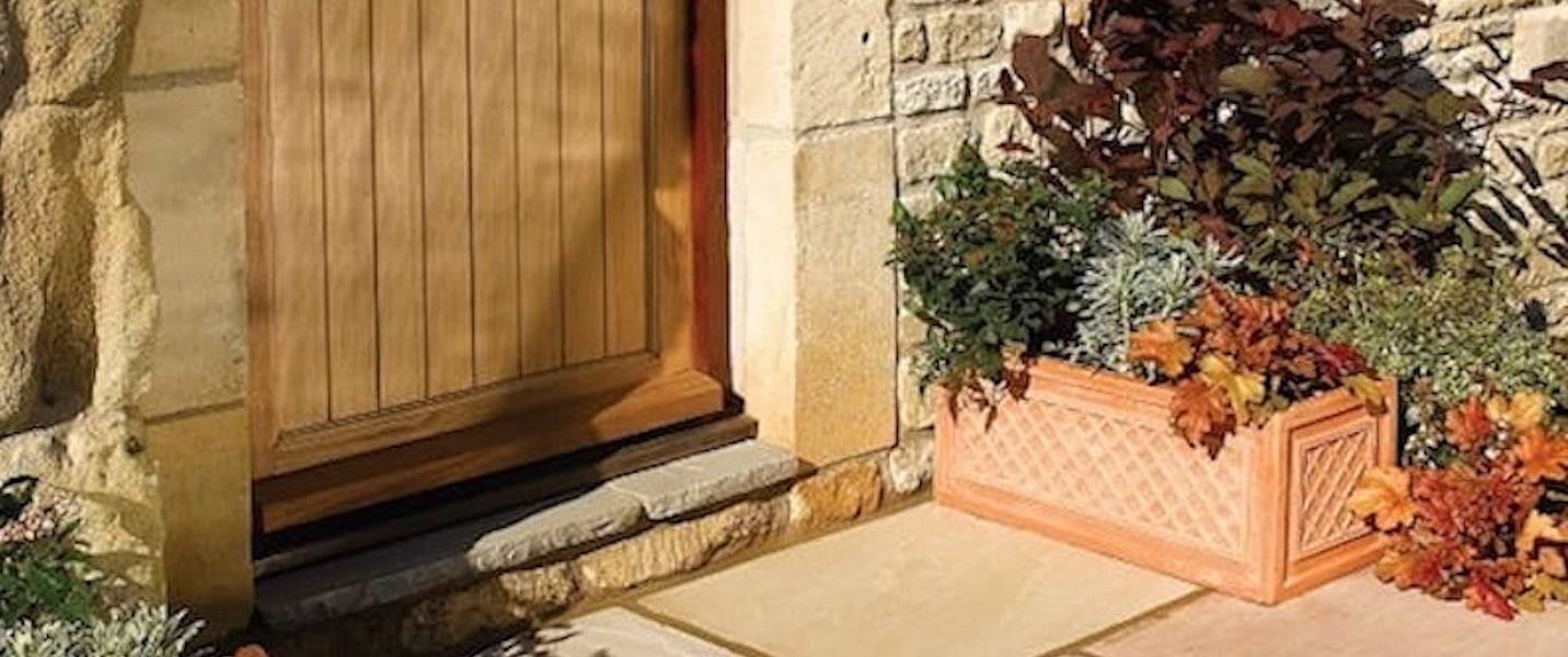 stone cottage with wooden door and sandstone paving