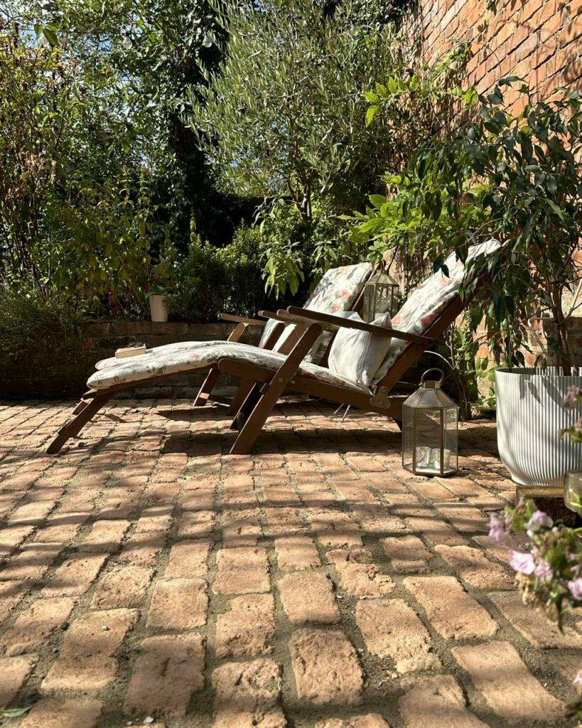 brick pavers with side on view of decking chairs and red brick wall